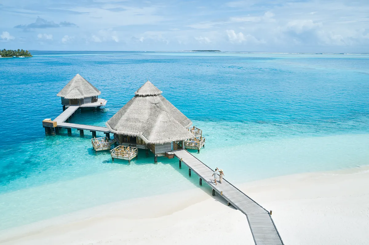 Aerial view of the overwater jetty and thatched villas at Conrad Maldives Rangali Island
