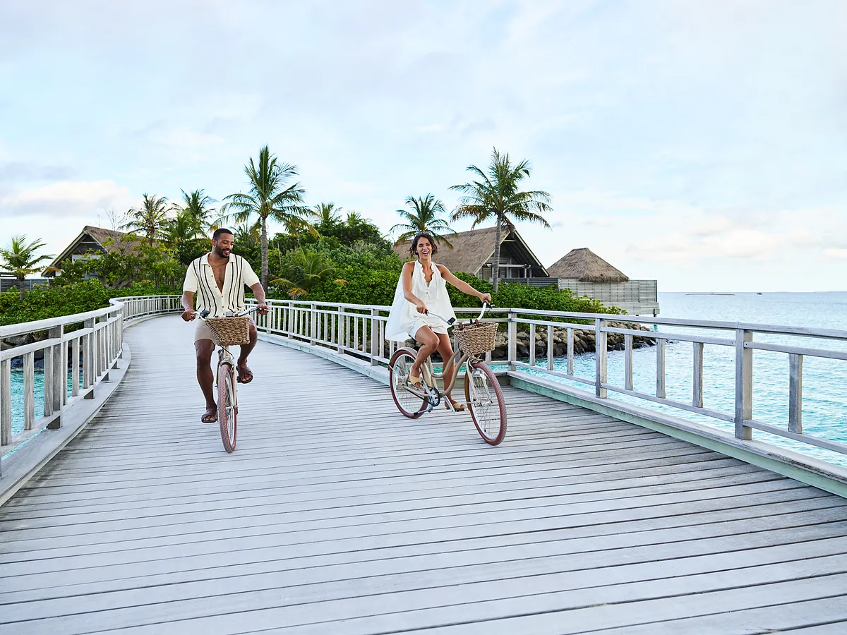 Guests cycling the connecting jetty at Conrad Maldives Rangali Island