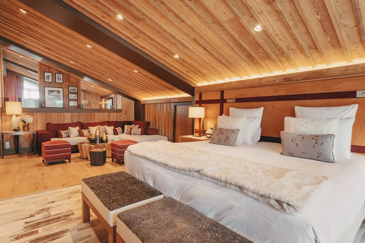 Penthouse bedroom under a timber ceiling at Hotel Barriere Les Neiges, photograph by November Studio