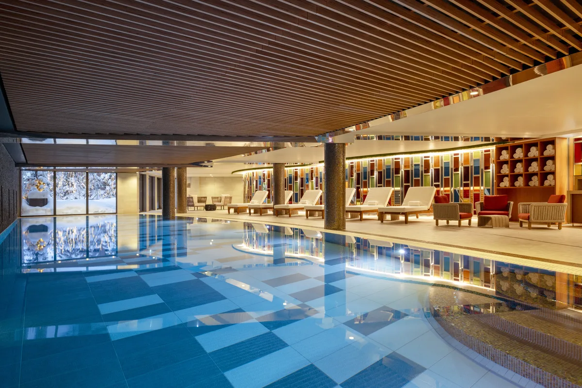 Indoor pool and loungers at Hotel Barriere Les Neiges
