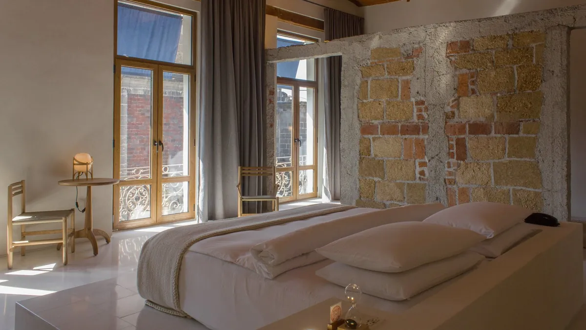 Monastic Shaker inspired room at Círculo Mexicano with an arched window and oak furniture from Taller Lu'um