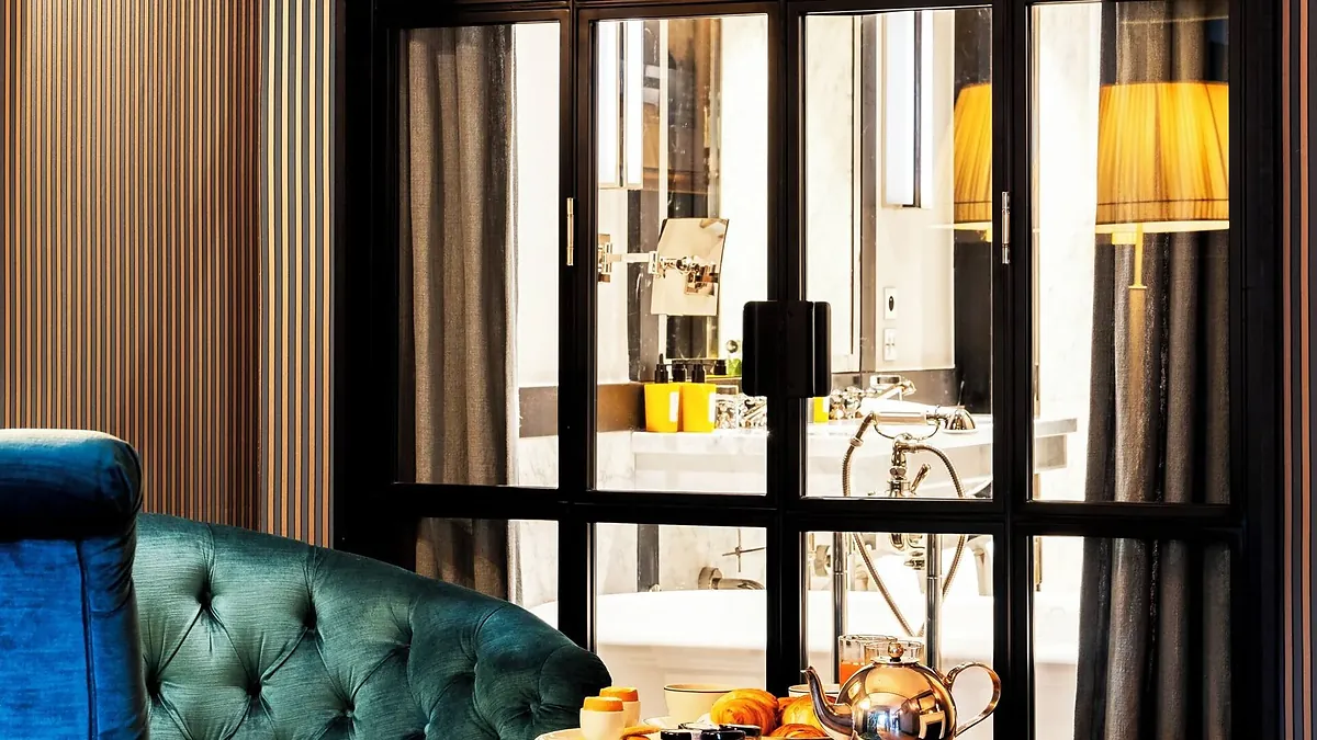 Lounge with a green velvet sofa at Hôtel de Berri Paris