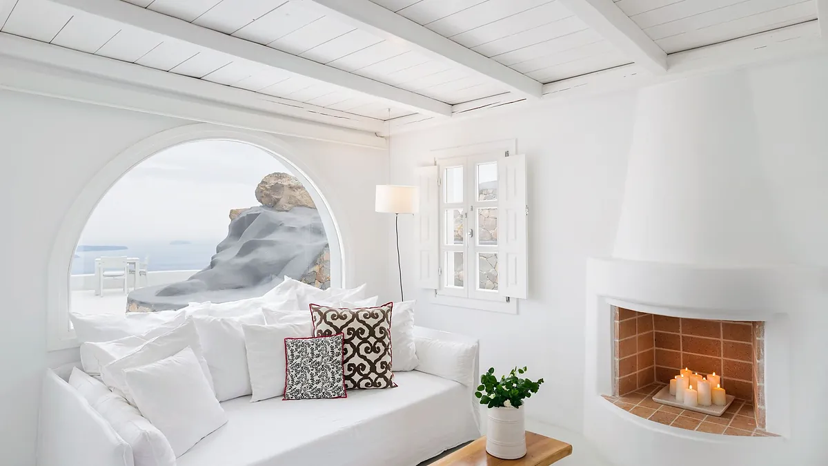 Arched window sofa fireplace at Aenaon Villas in Santorini