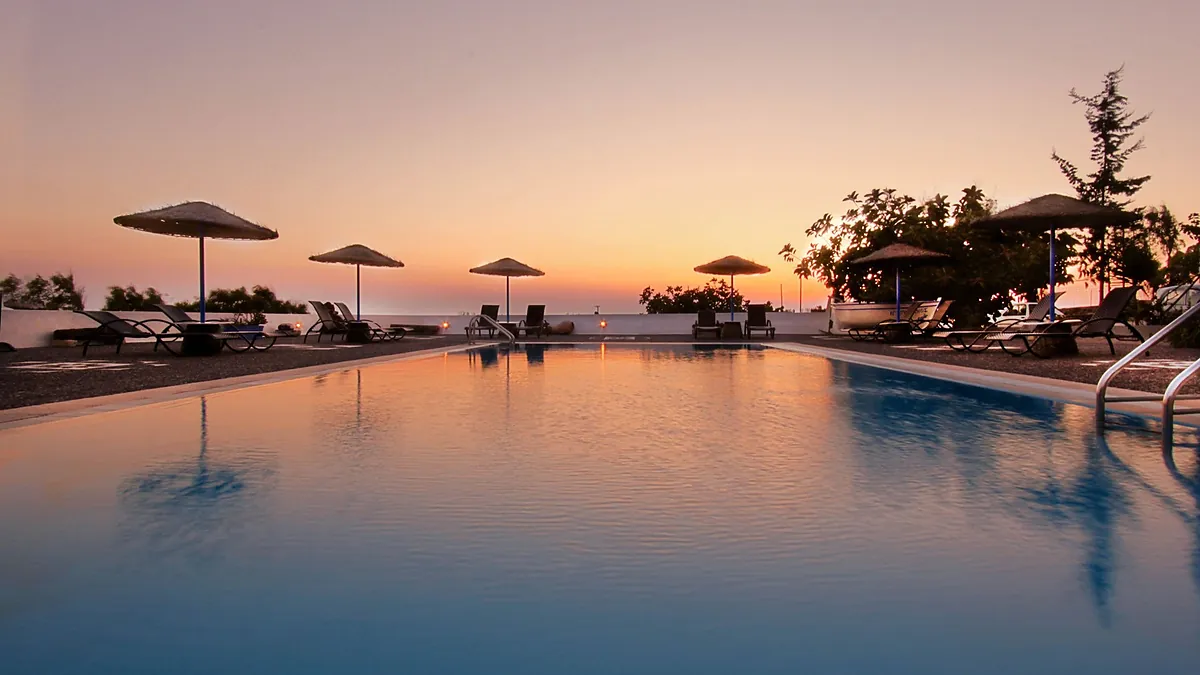 Poolside terrace at Caldera Romantica in Akrotiri, Santorini, looking across the caldera at sunset
