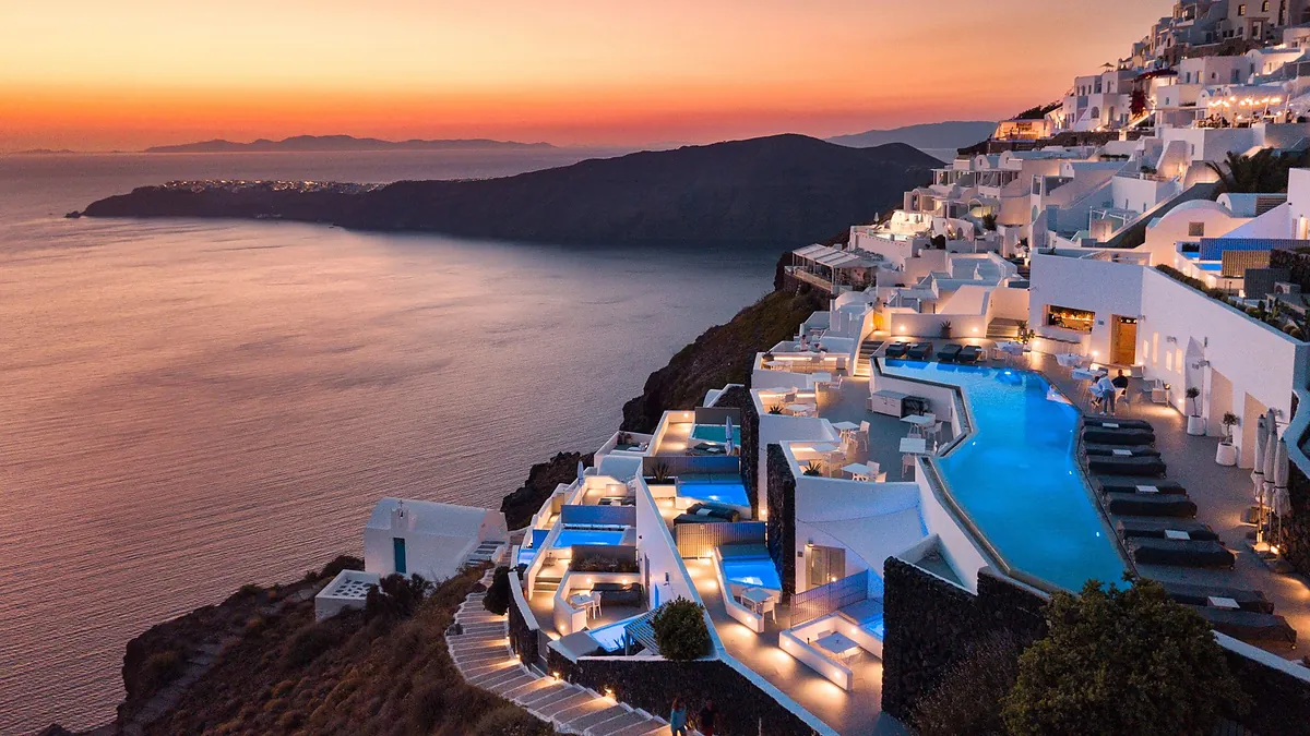 Infinity pool at Grace Hotel Santorini above the Imerovigli caldera at sunset