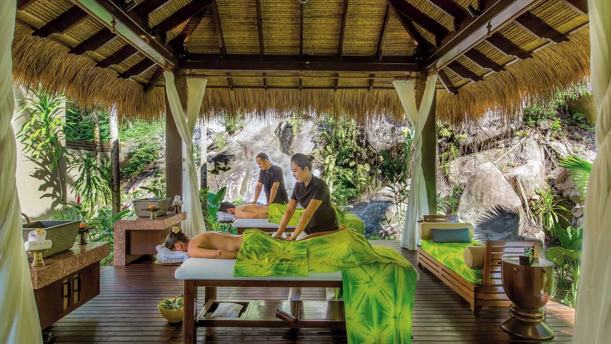 Outdoor spa treatment pavilion set against granite boulders at Anantara Maia Seychelles Villas