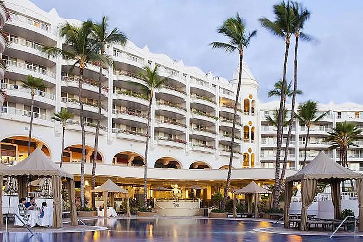 White all suite beachfront resort with layered swimming pools and palms in Wailea Maui