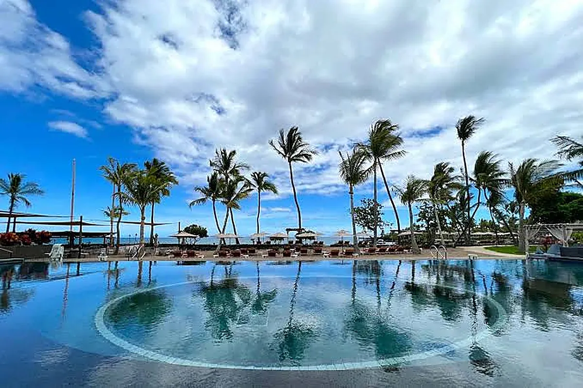 Thatched roof luxury bungalows beside a black lava rock bay on the Kohala Coast of Hawaii